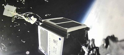 Videón ahogy az űrbe emelkedik és annak határán lebeg a fából készült műhold